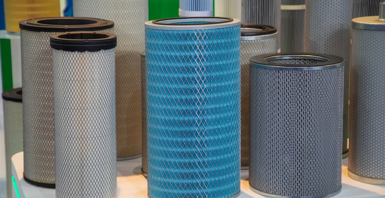Deux mains comparent un média filtrant tissé et une cartouche plissée.